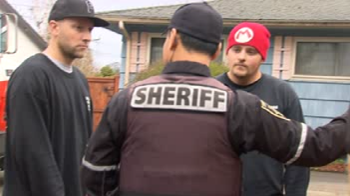 Jeff Rackley and Ruben Rael speaking with a deputy from the Multnomah County Sheriff's Office, March 11, 2015. (KOIN)