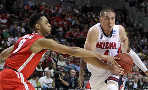 Arizona guard T.J. McConnell, right, drives on Ohio State guard D'Angelo Russell during an NCAA college basketball tournament round of 32 game in Portland, Ore., Saturday, March 21, 2015. (AP Photo/Craig Mitchelldyer)