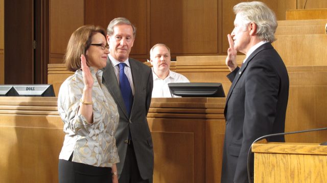 Gov. John Kitzhaber, right, administers the oath of office to Attorney General Ellen Rosenblum as Rosenblum's husband, Richard Meeker, watches at the state Capitol in Salem, Ore., on Friday, Jan. 4, 2013. (AP Photo/Jonathan J. Cooper)