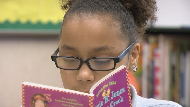 Rosa Parks Elementary student Fortune Gregory reads a Junie B. Jones book in the SuperSensory Literacy Space, May 19, 2015 (KOIN)