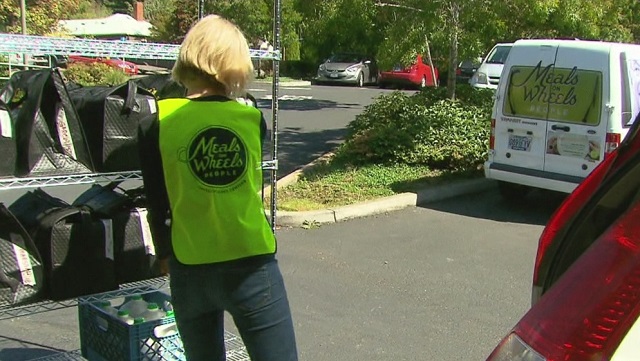 Photo shows former KOIN 6 News meteorologist Sally Showman volunteering and delivering meals for Meals 4 Kids.