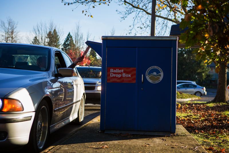 A voter casts his ballot at the drive-up drop box by Tigard City Hall on Nov. 8. (Portland Tribune)_375560