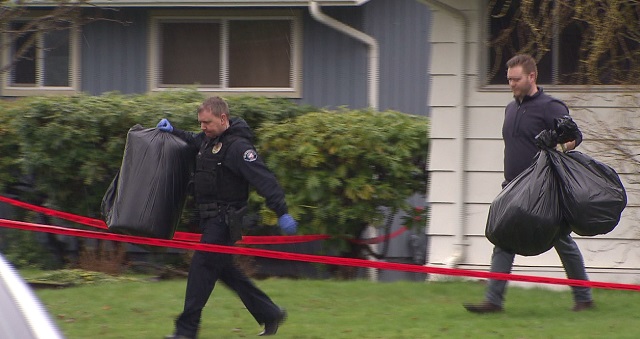 Police carry bags of evidence from the McMinnville home where a woman was shot to death, March 9, 2017 (KOIN)