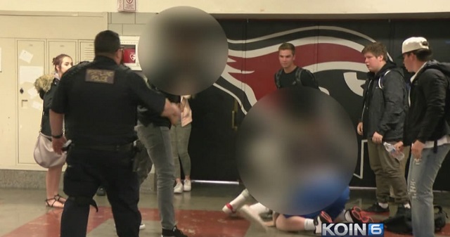 PPB Officer Tommy Stoffel, left, breaks up a student fight inside Lincoln High School, May 11, 2017 (KOIN)