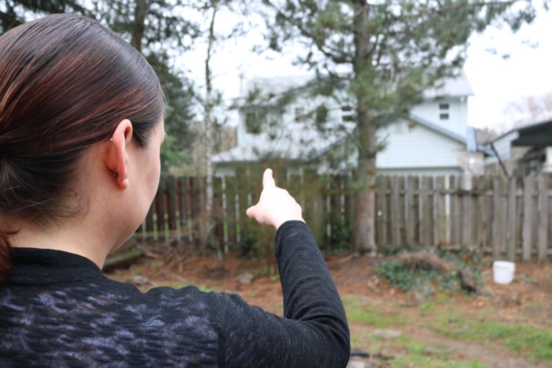 Jovan Nieto points from her backyard at Travis Dick's house. The 32-year-old fears for the safety of her four children.