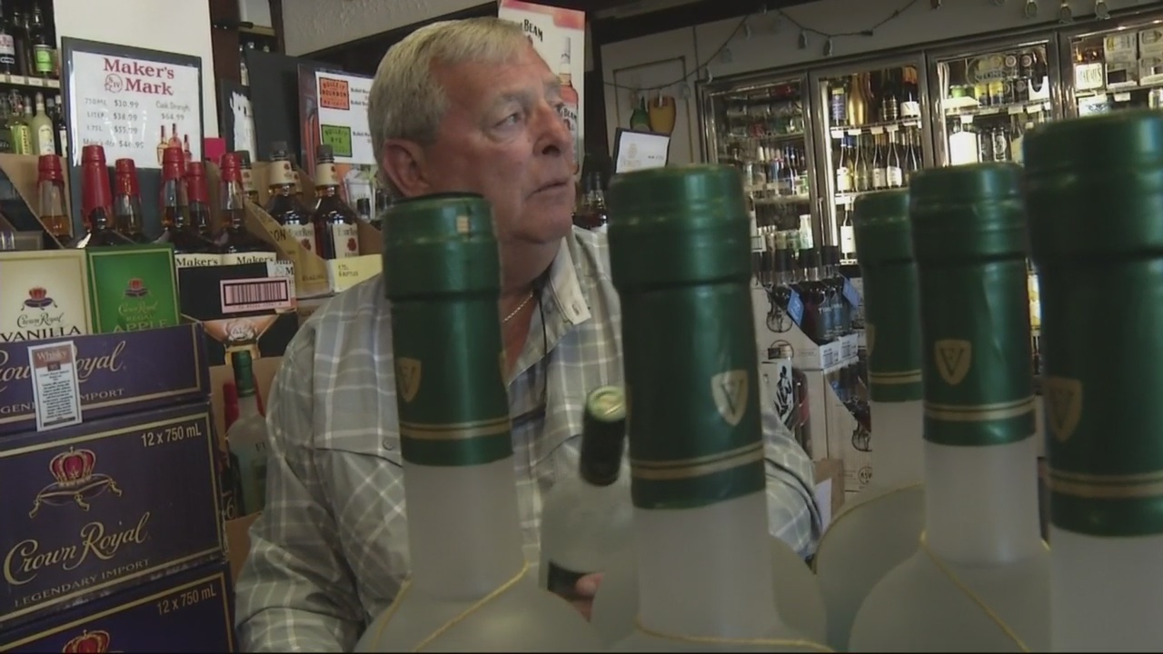 Masters champion Fuzzy Zoeller autographing bottles of his vodka