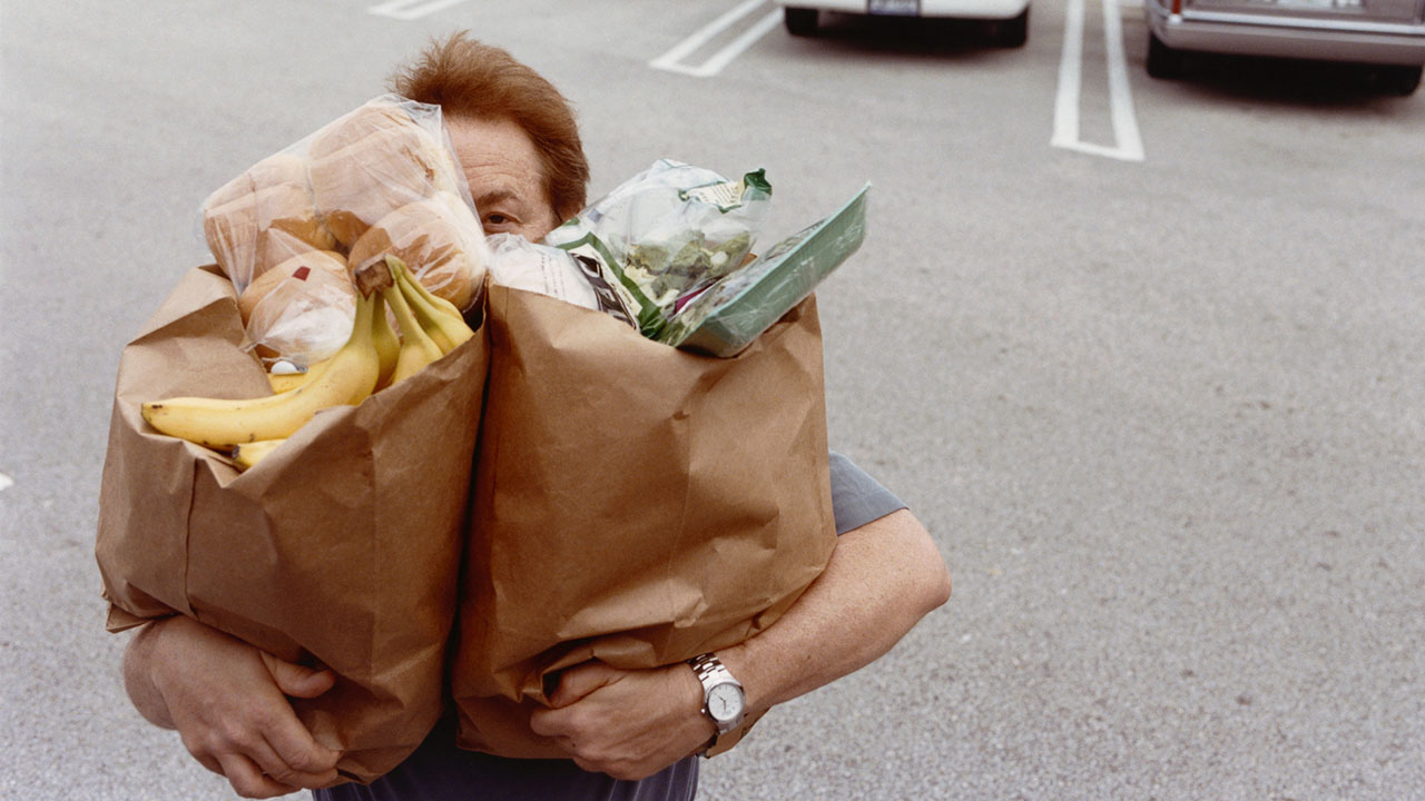 A man carrying paper grocery bags (Getty Images)