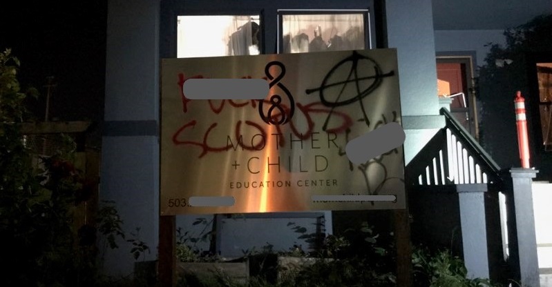 Vandals smashed windows and scrawled graffiti at the Mother + Child Education Center in Portland during a destructive march from Grant Park, June 25, 2022 (PPB)