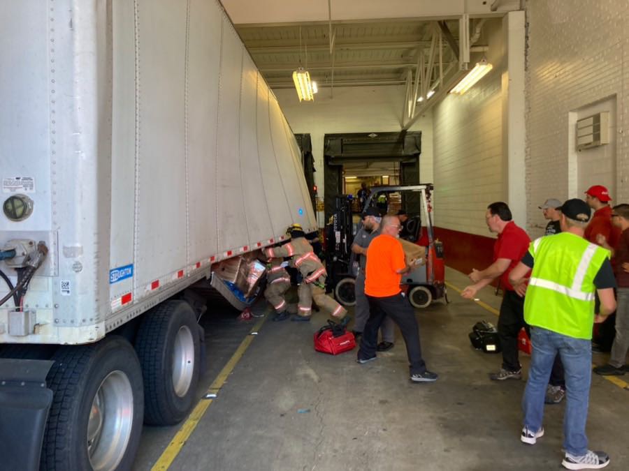 A person's hand was pinned against a semi-trailer after a forklift tipped over at the Coca-Cola plant in Northeast Portland Monday, according to officials.