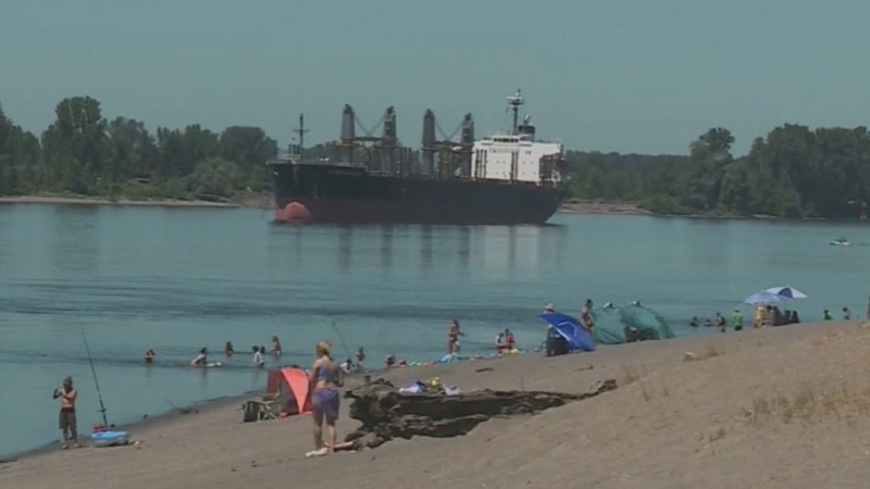 People on a beach along the Columbia River near Vancouver, July 19, 2022 (KOIN)