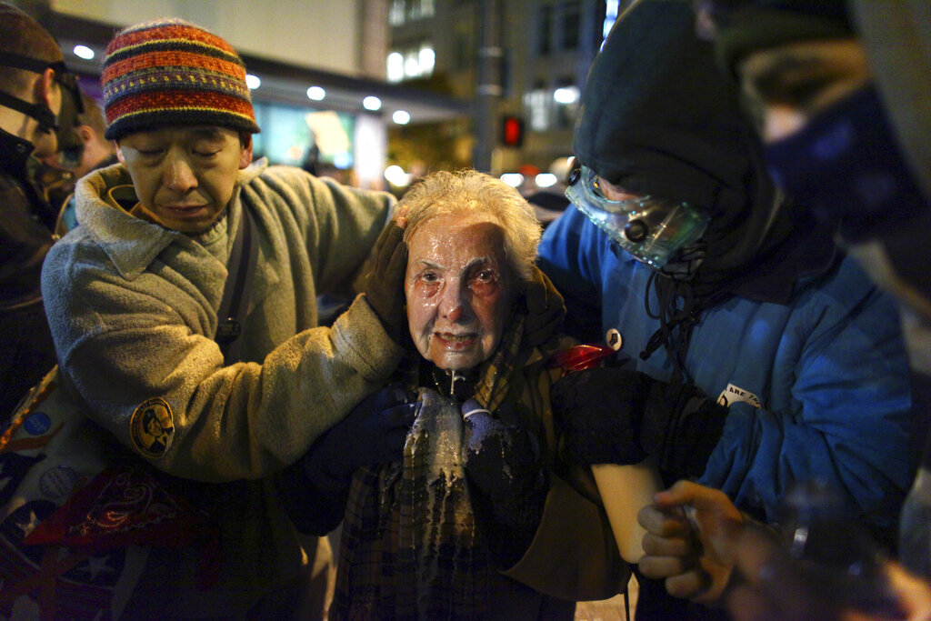 Seattle activist Dorli Rainey, 84, reacts after being hit with pepper spray during an Occupy Seattle protest on Nov. 15, 2011 at Westlake Park in Seattle. (Joshua Trujillo/seattlepi.com via AP, File)