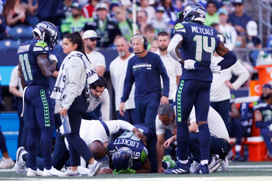 Tyler Lockett #16 of the Seattle Seahawks is tended to by medical staff after a play against the Atlanta Falcons during the second quarter at Lumen Field on September 25, 2022 in Seattle, Washington. (Photo by Steph Chambers/Getty Images)