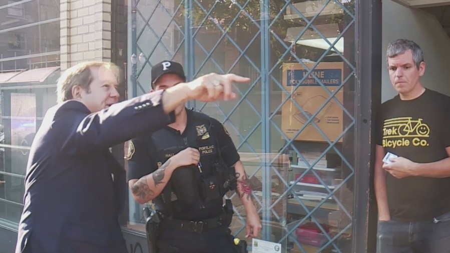 Portland business developer Jordan Schnitzer talks with police after windows in his SW Portland offices were smashed, September 27, 2022 (KOIN)