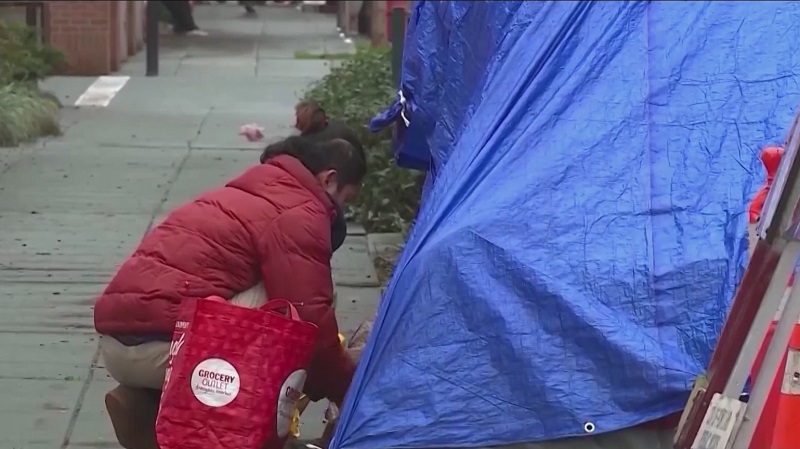 A person checking on a homeless tent in Portland, October 2022 (KOIN)
