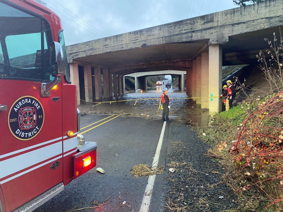 A car was stranded in high flood waters on a road underneath an Interstate 5 overpass in Aurora, Oregon on Tuesday, Dec. 27, 2022.