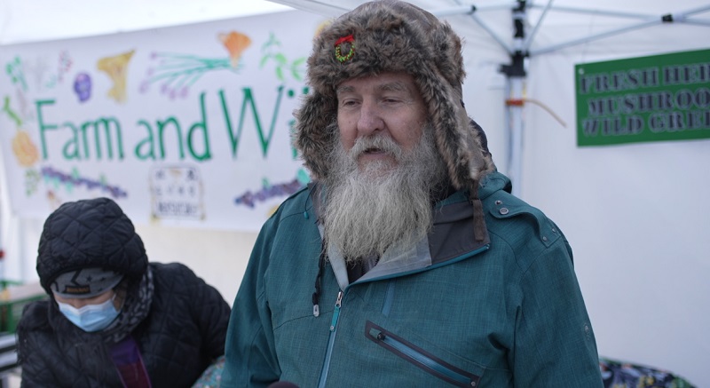 Charles Riley helps sell mushrooms at the Farm and Wild booth at the PSU Portland Farmers Market, December 2022 (KOIN)