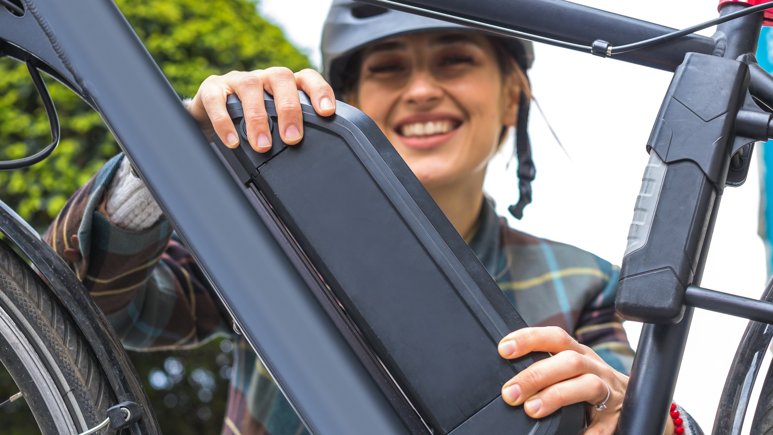 Woman holds an electric bike battery mounted on a frame. (Getty image)