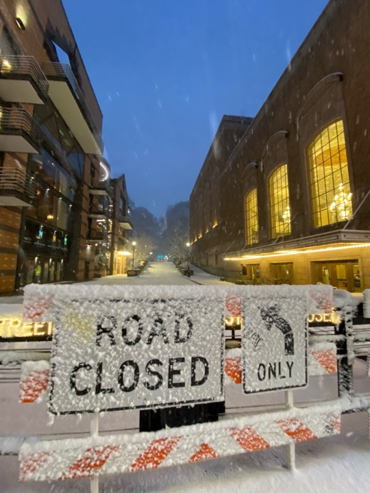 Snow-coated road closed sign