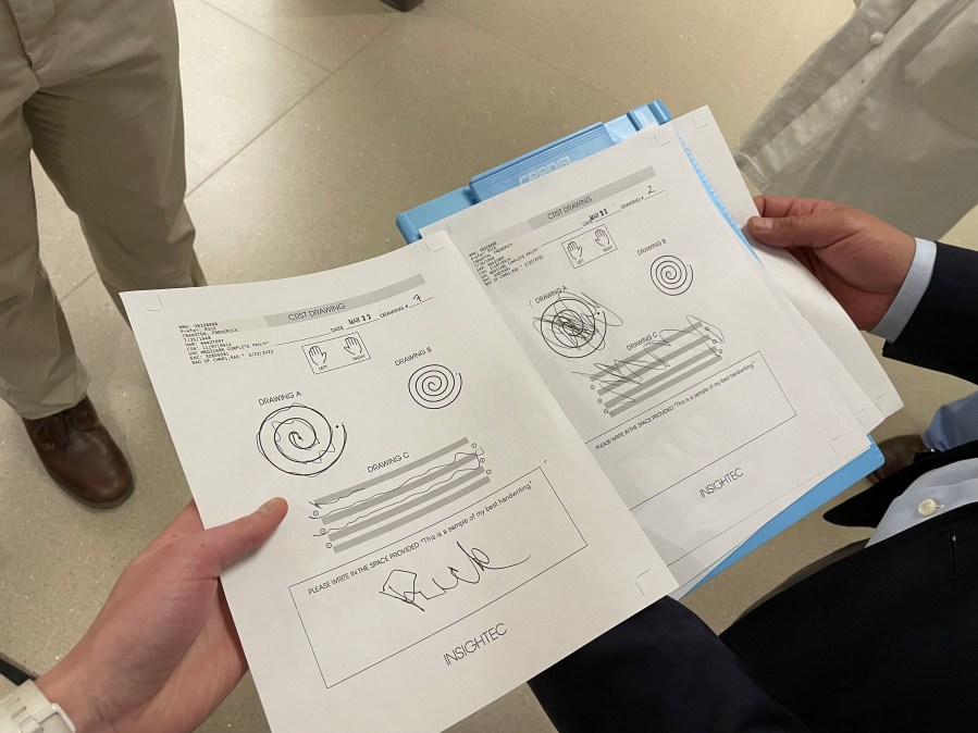 The paper on the right shows Rick Cranston's spiral test before his surgery. He was asked to trace the spiral, draw straight lights and write his name, which were all nearly impossible with his essential tremor. After the tremor was treated, the paper on the left shows how his hand function improved. Photo taken March 22, 2023 (KOIN)