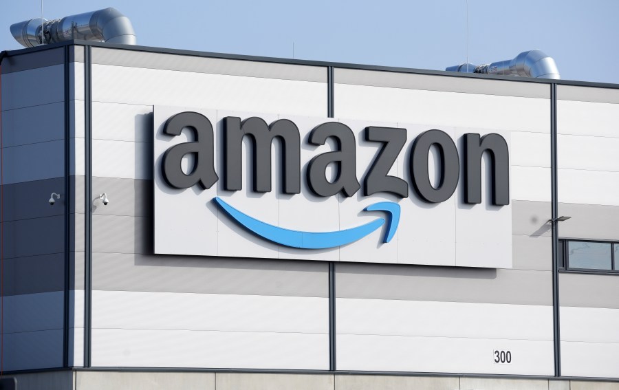 FILE - An Amazon company logo is seen on the facade of a company's building in Schoenefeld near Berlin, Germany, on March 18, 2022. British antitrust regulators have started investigating Amazon's purchase of robot vacuum maker iRobot, adding further scrutiny to the $1.7 billion deal. The Competition and Markets Authority said Thursday April 6, 2023 that it's considering whether the deal will result in a “substantial lessening of competition” within the United Kingdom. (AP Photo/Michael Sohn, File)