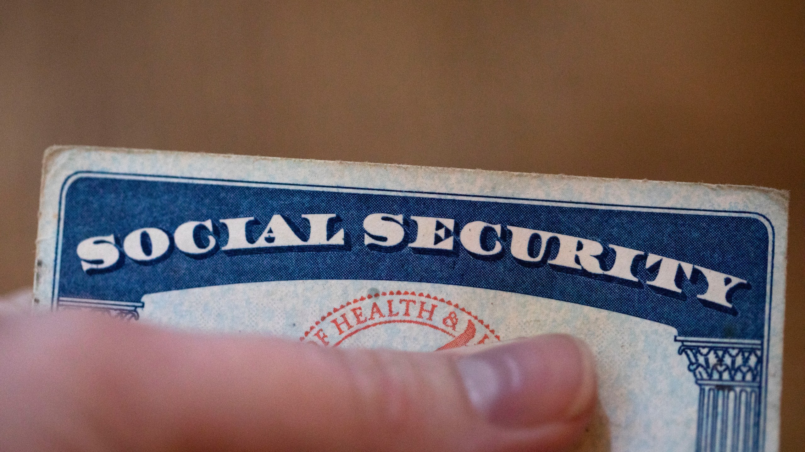 FILE - A Social Security card is displayed on Oct. 12, 2021, in Tigard, Ore. Most U.S. adults are opposed to proposals that would cut into Medicare or Social Security benefits, and a majority support raising taxes on the nation's highest earners to keep Medicare running as is. The new findings, revealed in a March poll by The Associated Press-NORC Center for Public Affairs Research, come as both safety net programs are poised to run out of enough cash to pay out full benefits within the next decade. (AP Photo/Jenny Kane, File)