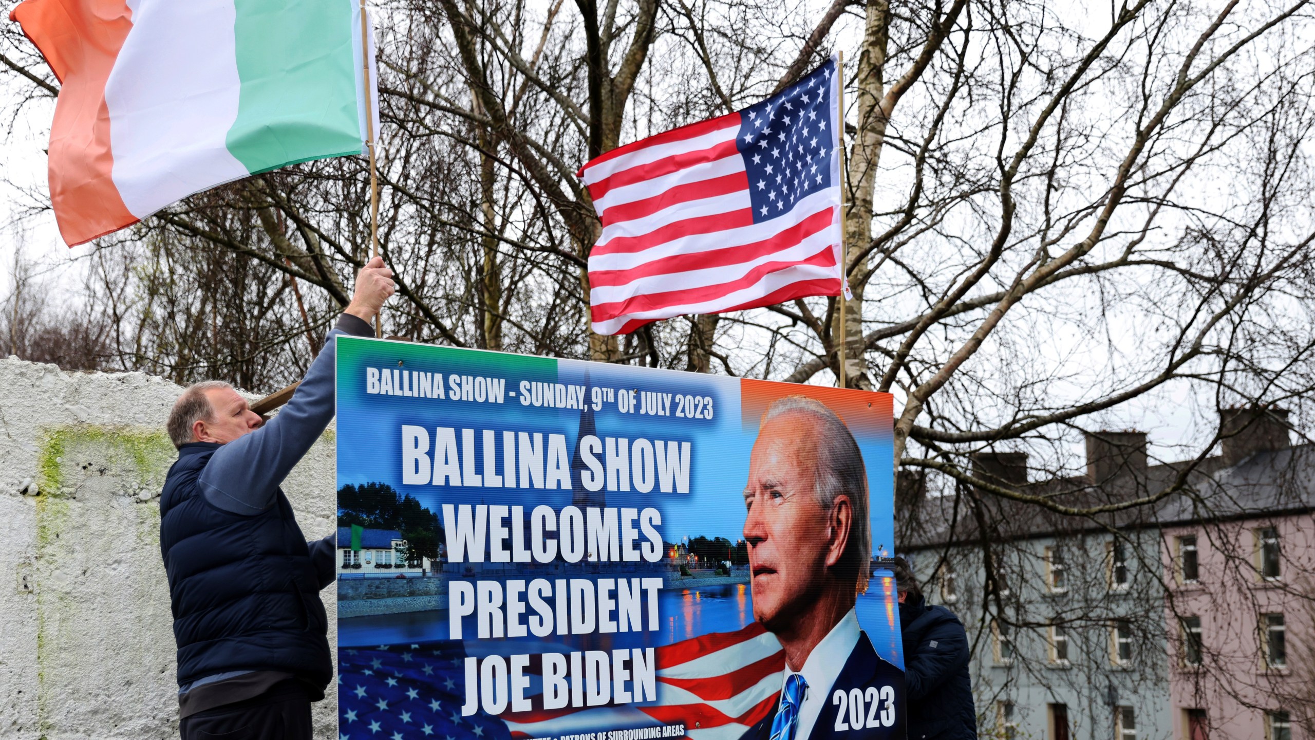 Ray Clarke, left, and Eddie Ruane put up flags in Ballina, Ireland, Tuesday, April, 4, 2023. Excitement is building in Ballina, a small Irish town that was home to some of President Joe Biden's ancestors. Biden is scheduled to visit the town next week, part of a four-day trip to Ireland and neighboring Northern Ireland. (AP Photo/Peter Morrison)