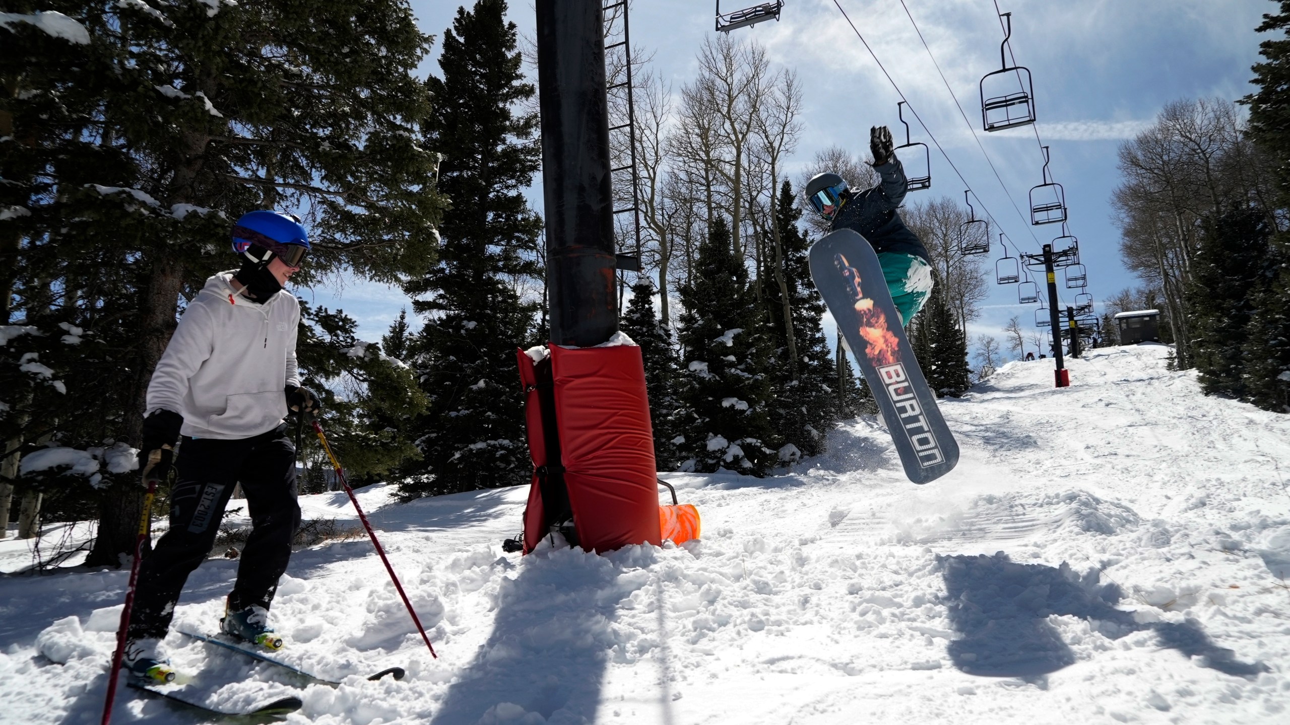 Race Lessar watches Landen Ozzello go off a jump they built at Parker-Fitzgerald Cuchara Mountain Park on Sunday, March 19, 2023, near Cuchara, Colo. Race Lessar's dad used to race here and named his son for what brought him joy. (AP Photo/Brittany Peterson)