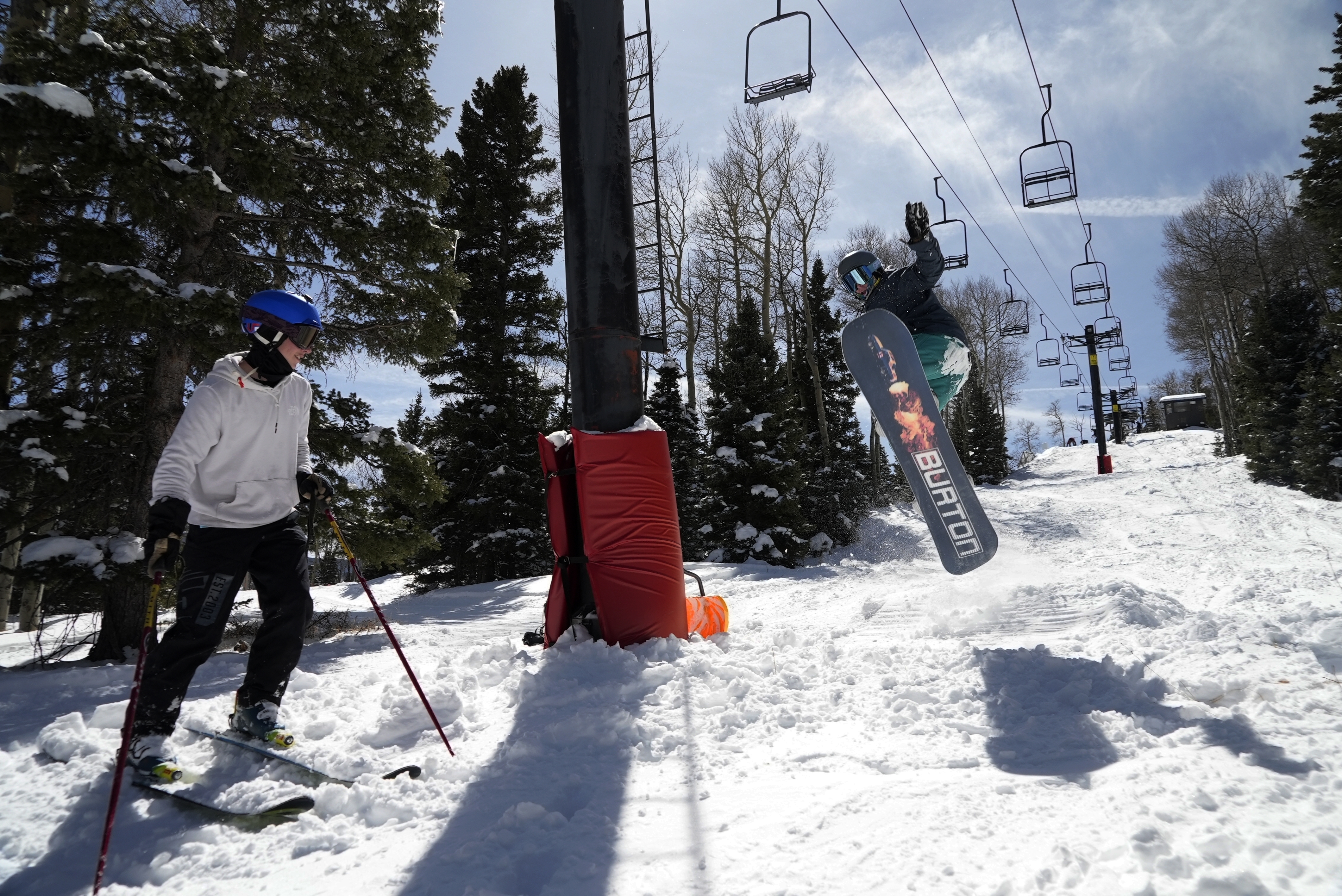 Race Lessar watches Landen Ozzello go off a jump they built at Parker-Fitzgerald Cuchara Mountain Park on Sunday, March 19, 2023, near Cuchara, Colo. Race Lessar's dad used to race here and named his son for what brought him joy. (AP Photo/Brittany Peterson)