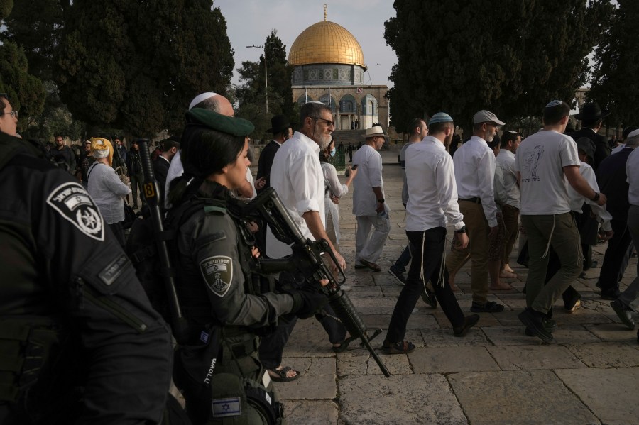 Israeli police escort Jewish visitors marking the holiday pf Passover to the Al-Aqsa Mosque compound, known to Muslims as the Noble Sanctuary and to Jews as the Temple Mount, in the Old City of Jerusalem during the Muslim holy month of Ramadan, Sunday, April 9, 2023. (AP Photo/Mahmoud Illean)