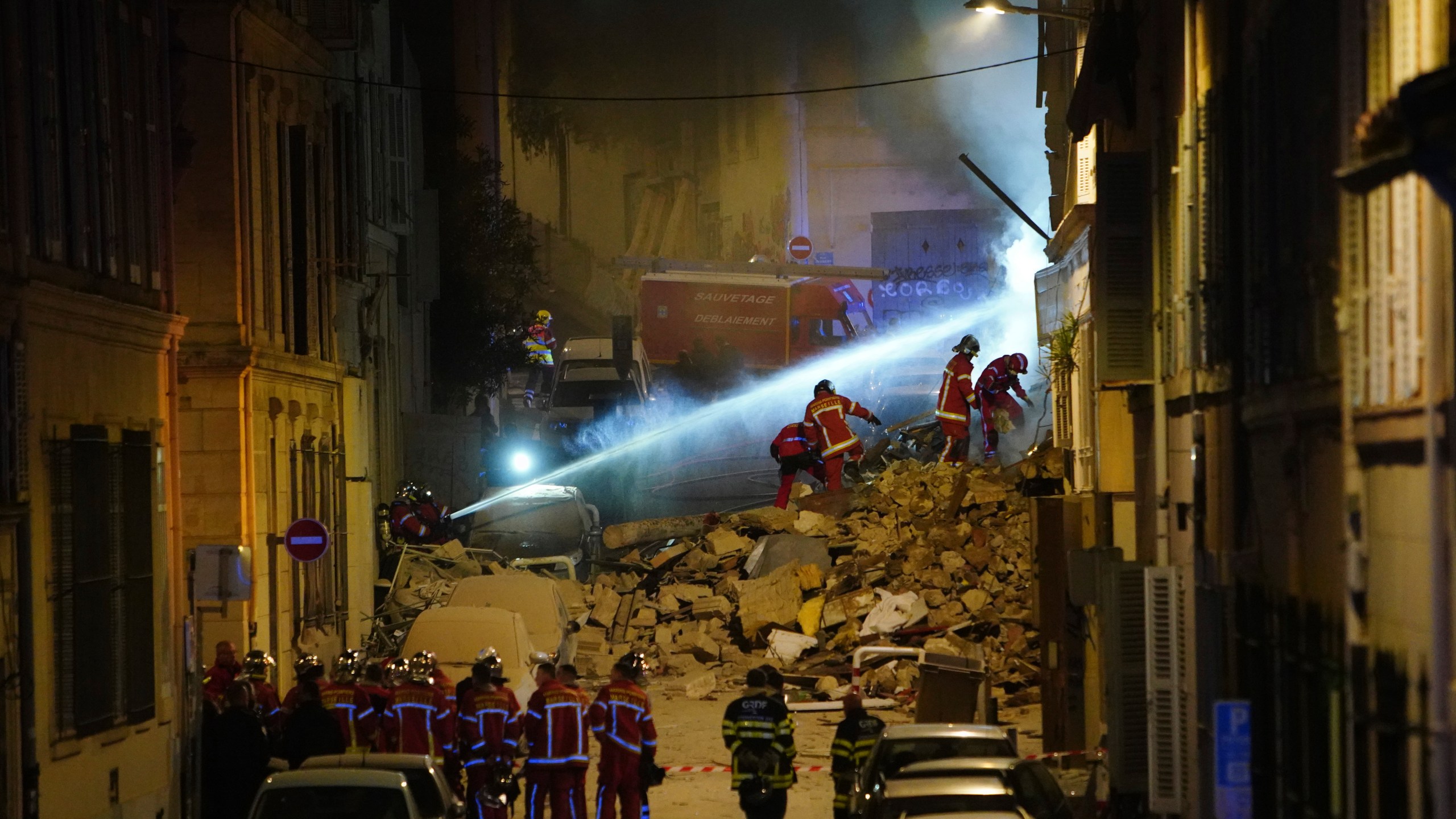 Firefighters work after building collapsed early Sunday, April 9, 2023 in Marseille, southern France. A residential building in France's port city of Marseille collapsed in a loud explosion early Sunday followed by a fire deep within the rubble that hindered rescue efforts. (AP Photo)