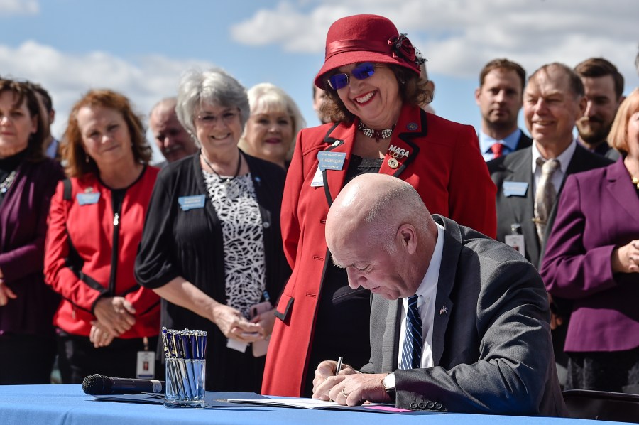 FILE - Republican Gov. Greg Gianforte signs one of three bills restricting access to abortion in Montana as sponsor of one of the bills, state Rep. Lola Sheldon-Galloway, R-Great Falls, watches in Helena, Mont., on April 26, 2021. Planned Parenthood of Montana filed a preemptive lawsuit Monday, April 10, 2023, seeking to stop legislation that would ban the abortion method most commonly used in the second trimester, arguing it's unconstitutional. (Thom Bridge/Independent Record via AP, File)