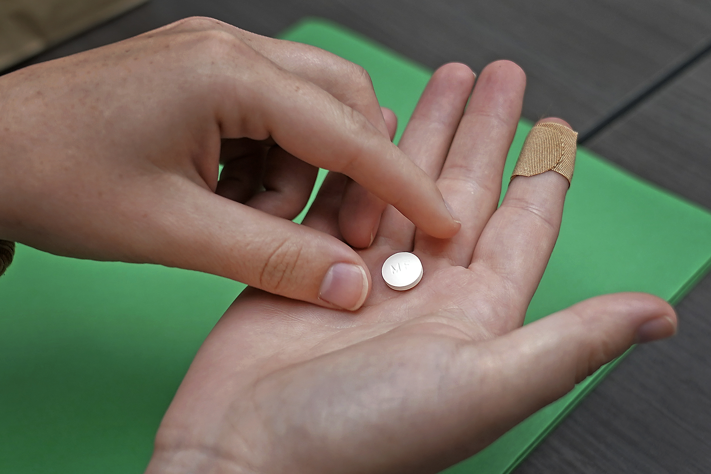 FILE - A patient prepares to take the first of two pills for a medication abortion during a visit to a clinic in Kansas City, Kan., on Wednesday, Oct. 12, 2022. Some abortion clinics are fielding lots of calls from patients since a Friday, April 7, 2023 court ruling threatened the availability of a main drug used in medication abortion, mifepristone. Patients are concerned about whether they can still get the care they need. (AP Photo/Charlie Riedel, File)