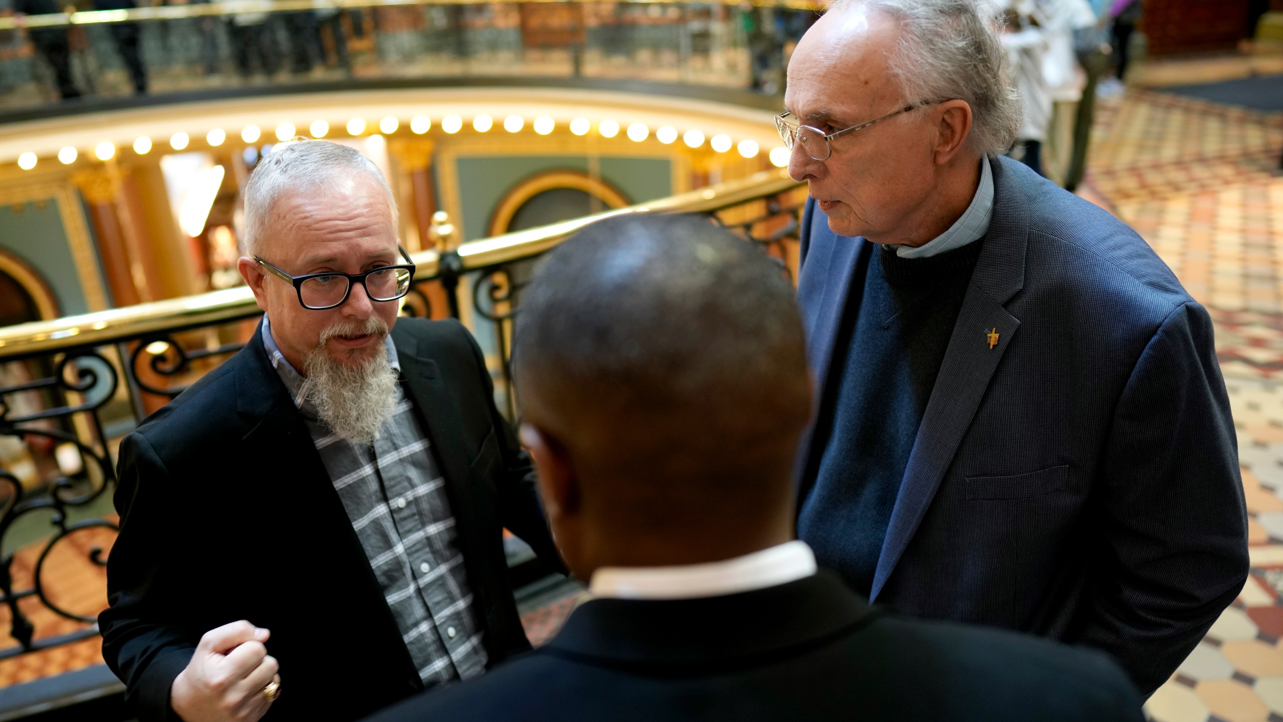 Rev. Mike Demastus, of Des Moines, Iowa, left, and Rev. Bob Curry, of Johnston, Iowa, right, talk with State Rep. Eddie Andrews, center, Thursday, April 6, 2023, at the Statehouse in Des Moines, Iowa. (AP Photo/Charlie Neibergall)