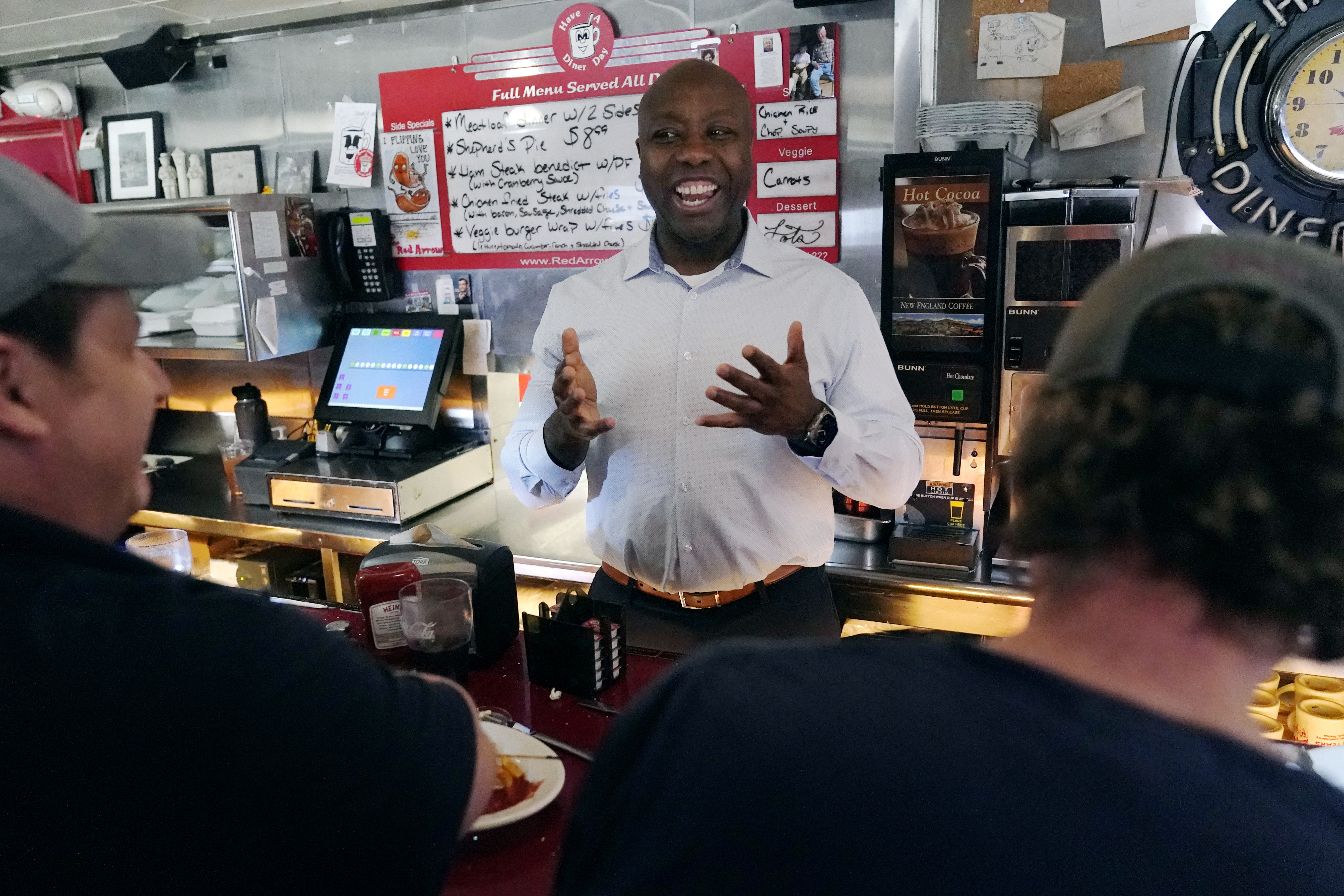 Sen. Tim Scott, R-S.C., talks with diners at the breakfast counter during a visit to the Red Arrow Diner, Thursday, April 13, 2023, in Manchester, N.H. Scott on Wednesday launched an exploratory committee for a 2024 GOP presidential bid, a step that comes just shy of making his campaign official. (AP Photo/Charles Krupa)