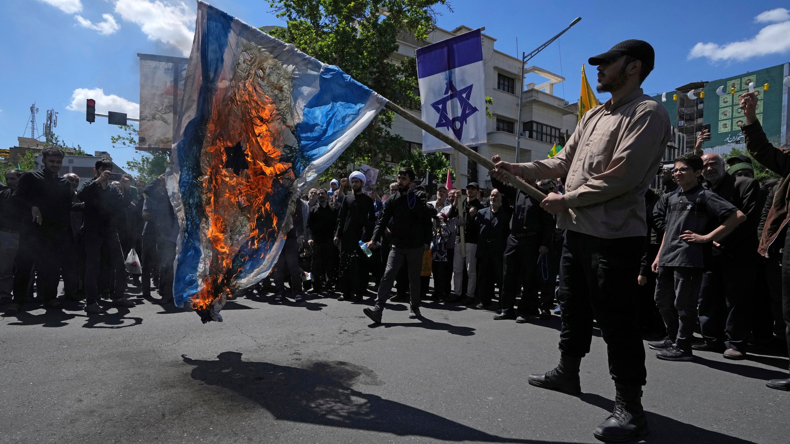 Iranian demonstrators burn a representation of the Israeli flag in their rally to mark Jerusalem Day, an annual show of support for the Palestinians, in Tehran, Iran, Friday, April 14, 2023. (AP Photo/Vahid Salemi)