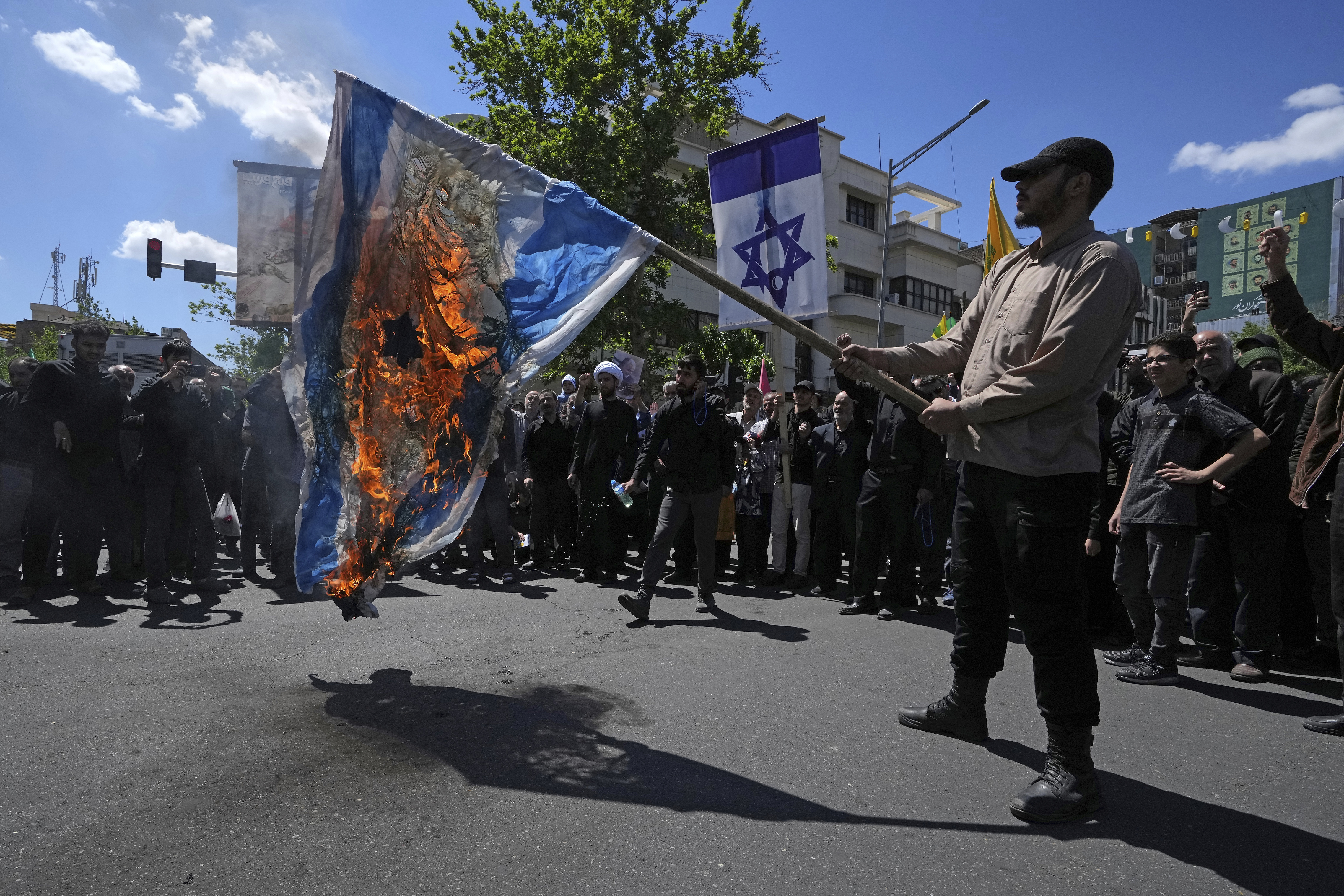 Iranian demonstrators burn a representation of the Israeli flag in their rally to mark Jerusalem Day, an annual show of support for the Palestinians, in Tehran, Iran, Friday, April 14, 2023. (AP Photo/Vahid Salemi)