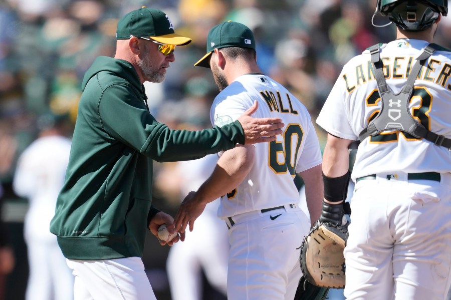 Oakland Athletics manager Mark Kotsay, left, makes a pitching change as he relieves pitcher Sam Moll (60) during the 10th inning of a baseball game against the New York Mets in Oakland, Calif., Sunday, April 16, 2023. (AP Photo/Jeff Chiu)