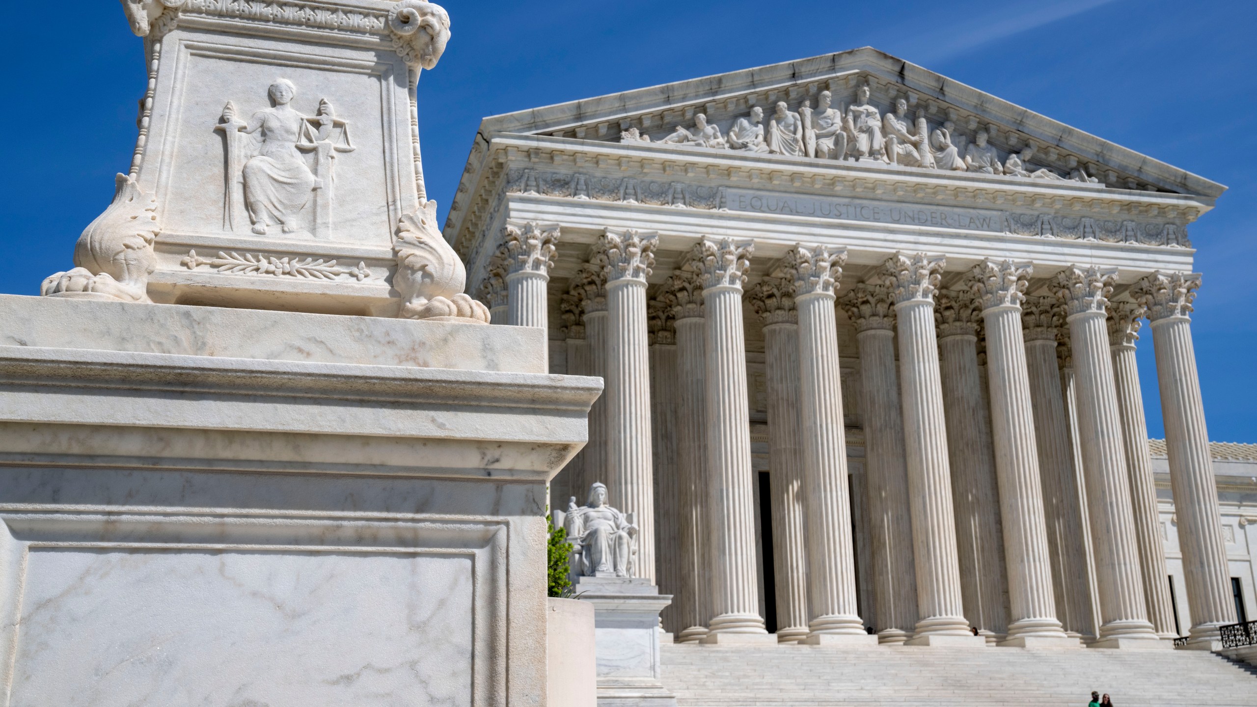 FILE - The Supreme Court is seen, with a carving of Justice in the foreground, April 19, 2023, in Washington. The Supreme Court is facing a self-imposed Friday night deadline to decide whether women’s access to a widely used abortion pill will stay unchanged until a legal challenge to its Food and Drug Administration approval is resolved. (AP Photo/Jacquelyn Martin, File)