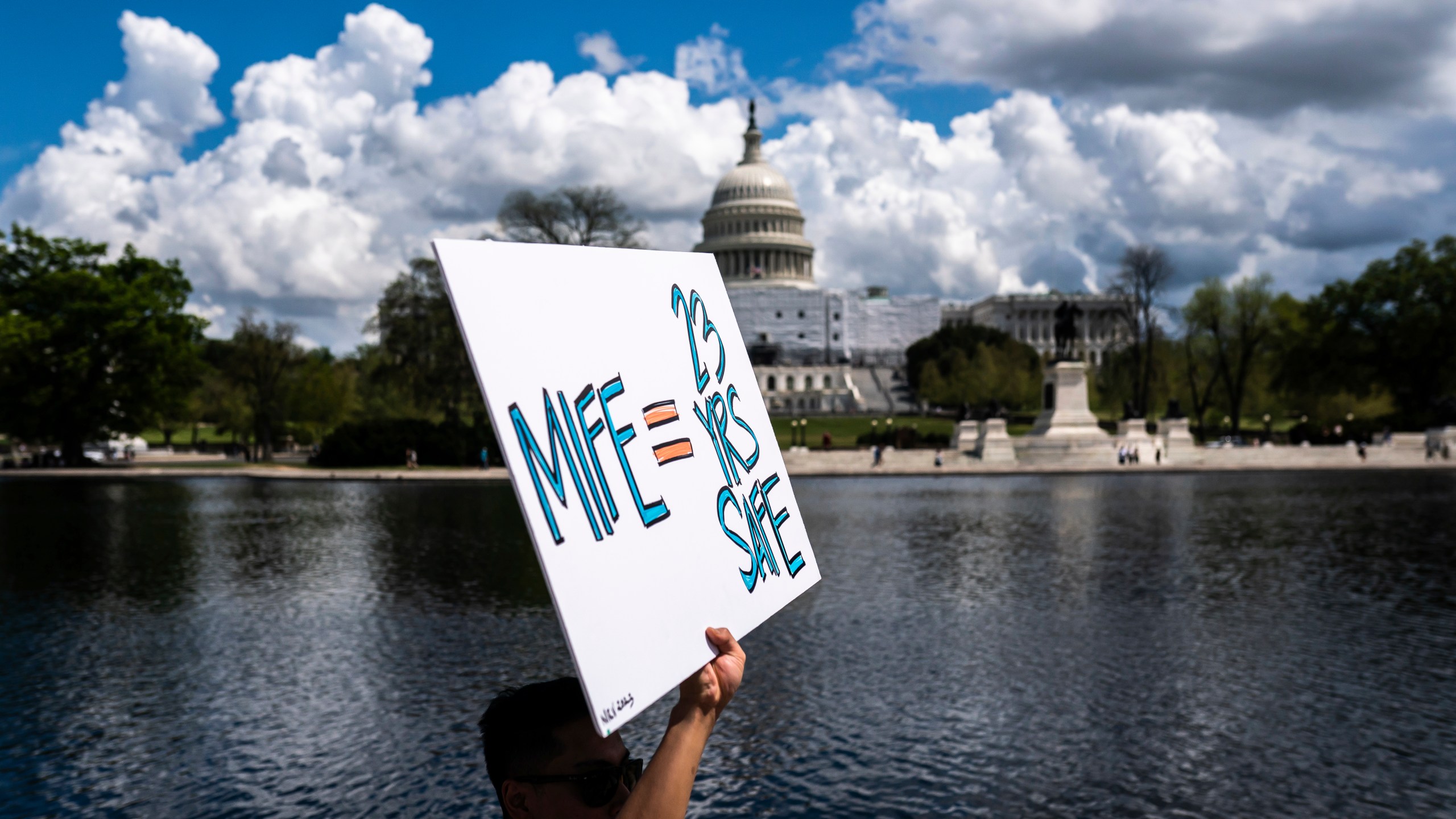 With the U.S. Capitol in the background, a protester holds a sign in support of mifepristone as they march past the capitol following a Planned Parenthood rally in support of abortion access outside the Supreme Court on Saturday, April. 15, 2023, in Washington. (AP Photo/Nathan Howard)