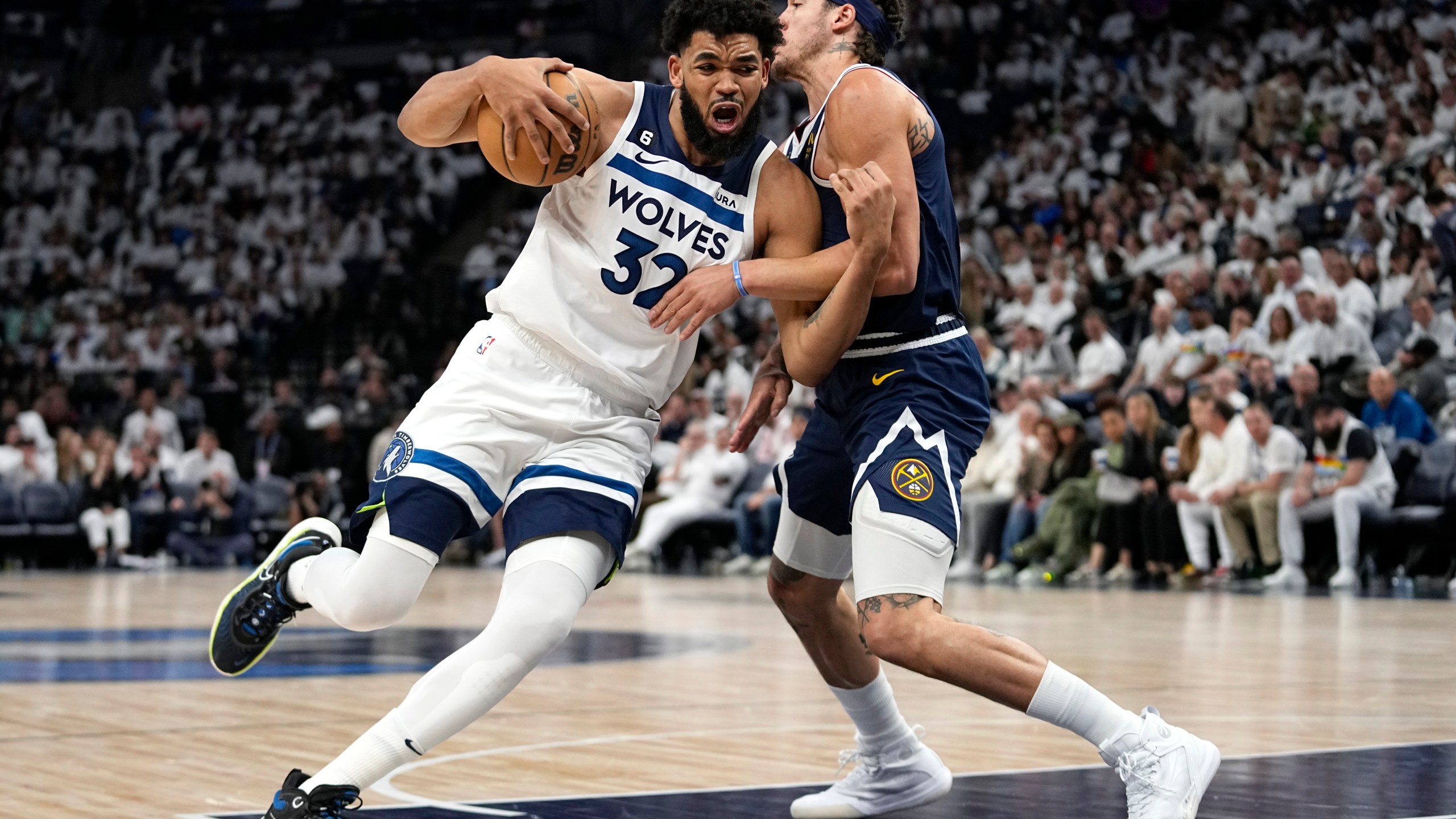 Minnesota Timberwolves center Karl-Anthony Towns (32) works toward the basket while defended by Denver Nuggets forward Aaron Gordon (50) during the second half of Game 4 of an NBA basketball first-round playoff series Sunday, April 23, 2023, in Minneapolis. (AP Photo/Abbie Parr)