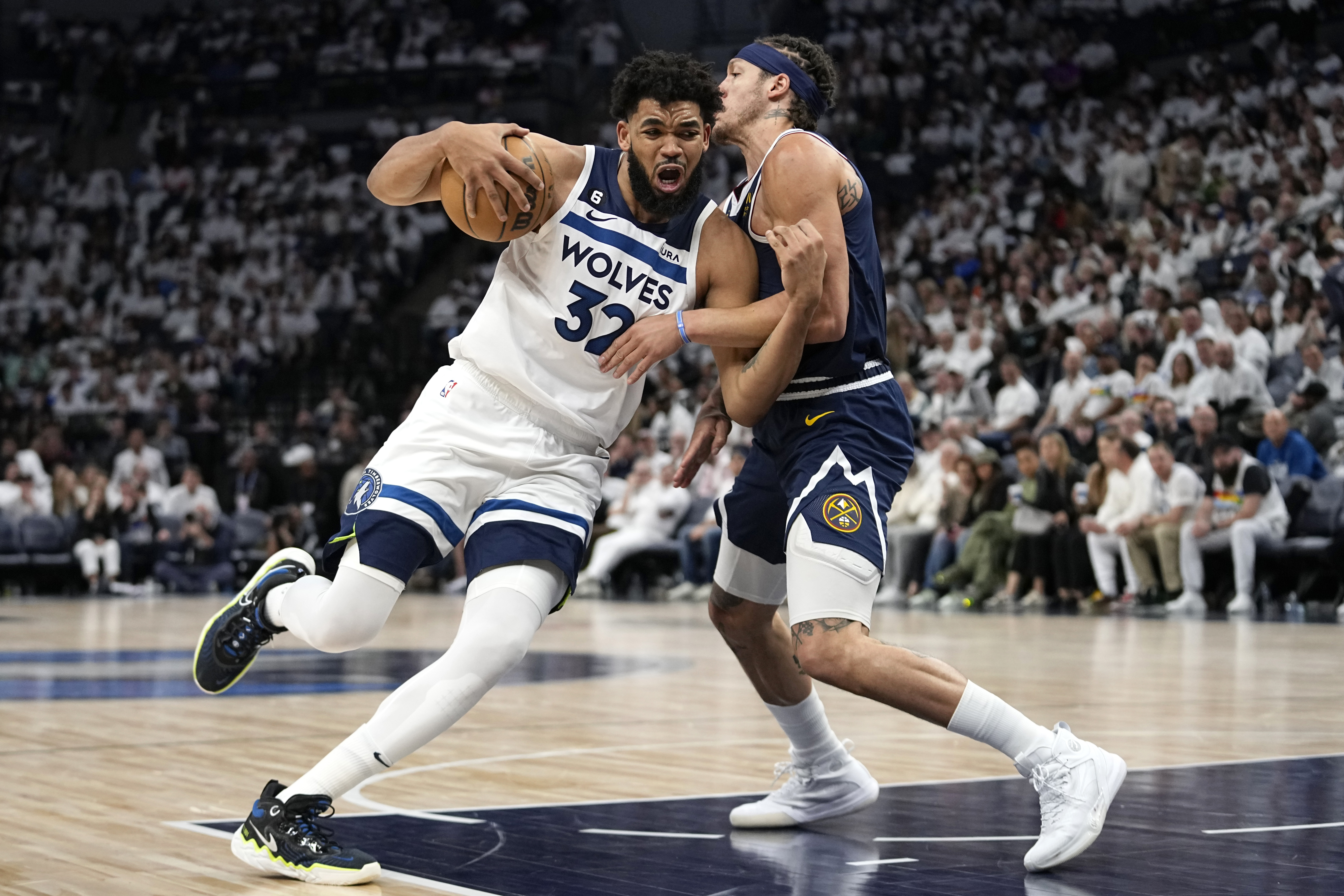 Minnesota Timberwolves center Karl-Anthony Towns (32) works toward the basket while defended by Denver Nuggets forward Aaron Gordon (50) during the second half of Game 4 of an NBA basketball first-round playoff series Sunday, April 23, 2023, in Minneapolis. (AP Photo/Abbie Parr)