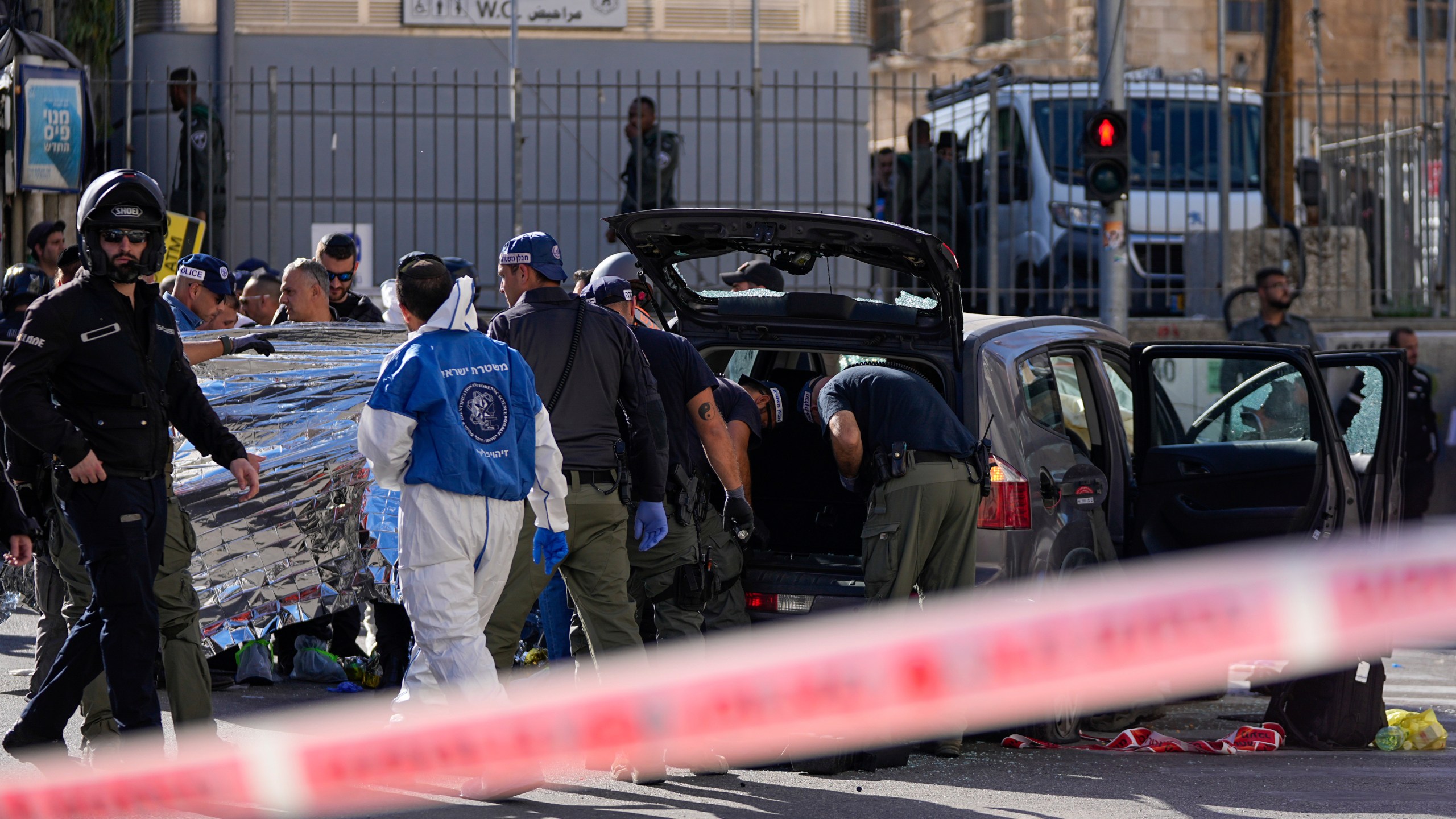 Israeli police examine the scene of a car ramming attack, in Jerusalem, Monday, April 24, 2023. Israeli Prime Minister Benjamin Netanyahu says multiple people have been attacked and wounded near a popular market in Jerusalem. (AP Photo/Ohad Zwigenberg)