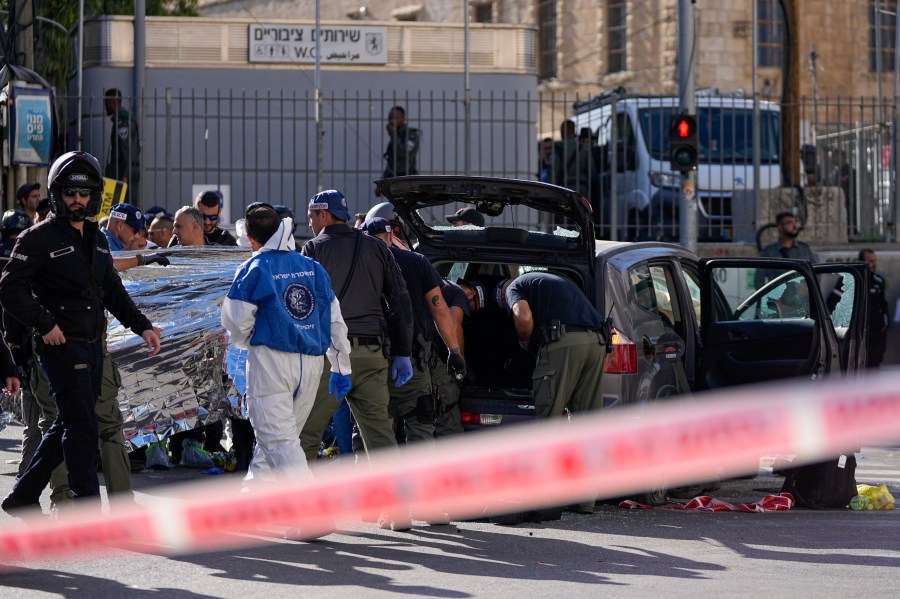 Israeli police examine the scene of a car ramming attack, in Jerusalem, Monday, April 24, 2023. Israeli Prime Minister Benjamin Netanyahu says multiple people have been attacked and wounded near a popular market in Jerusalem. (AP Photo/Ohad Zwigenberg)