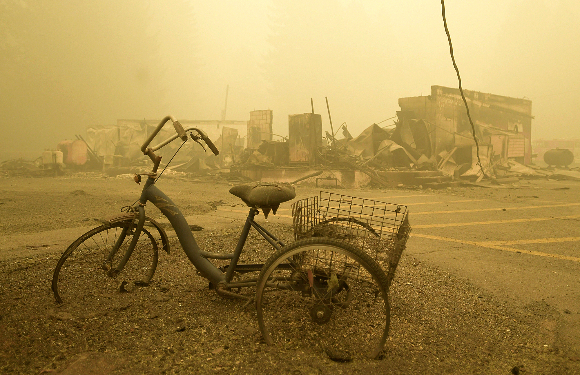 FILE - A trike stands near the burnt remains of a building destroyed by a wildfire near the Lake Detroit Market in Detroit, Ore., Sept. 11, 2020. A trial started Tuesday, April 25, 2023, in connection with a $1.6 billion class action lawsuit against utility PacifiCorp over the catastrophic Labor Day 2020 wildfires in Oregon. (Mark Ylen/Albany Democrat-Herald via AP, File)