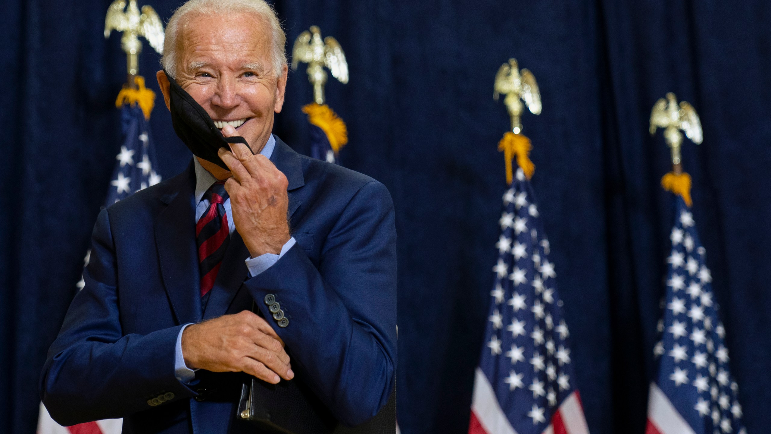 FILE - Democratic presidential candidate former Vice President Joe Biden smiles as he puts on his face mask after speaking to media in Wilmington, Del., on Sept. 4, 2020. (AP Photo/Carolyn Kaster, File)