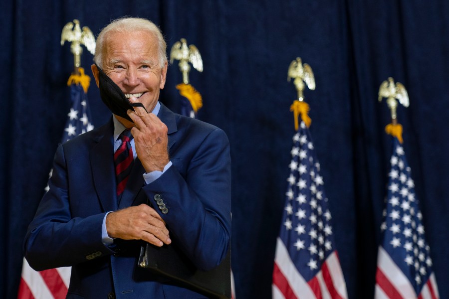 FILE - Democratic presidential candidate former Vice President Joe Biden smiles as he puts on his face mask after speaking to media in Wilmington, Del., on Sept. 4, 2020. (AP Photo/Carolyn Kaster, File)