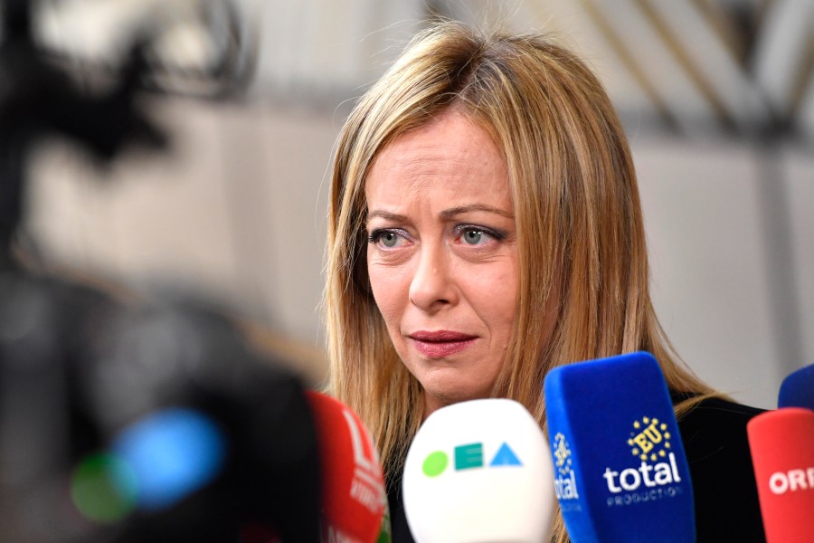 FILE - Italy's Prime Minister Giorgia Meloni speaks with the media as she arrives for an EU summit at the European Council building in Brussels, Thursday, March 23, 2023. The Italian Coast Guard said Monday, April 24 some 1,200 migrants have arrived since Sunday on the tiny Italian island of Lampedusa. Although far-right Premier Giorgia Meloni has led a crackdown both on smugglers and on the charity vessels, migrants keep risking dangerous voyages in the Central Mediterranean — departing from Tunisia, Libya and Turkey — in hopes of finding work or relatives in Europe. (AP Photo/Geert Vanden Wijngaert, file)