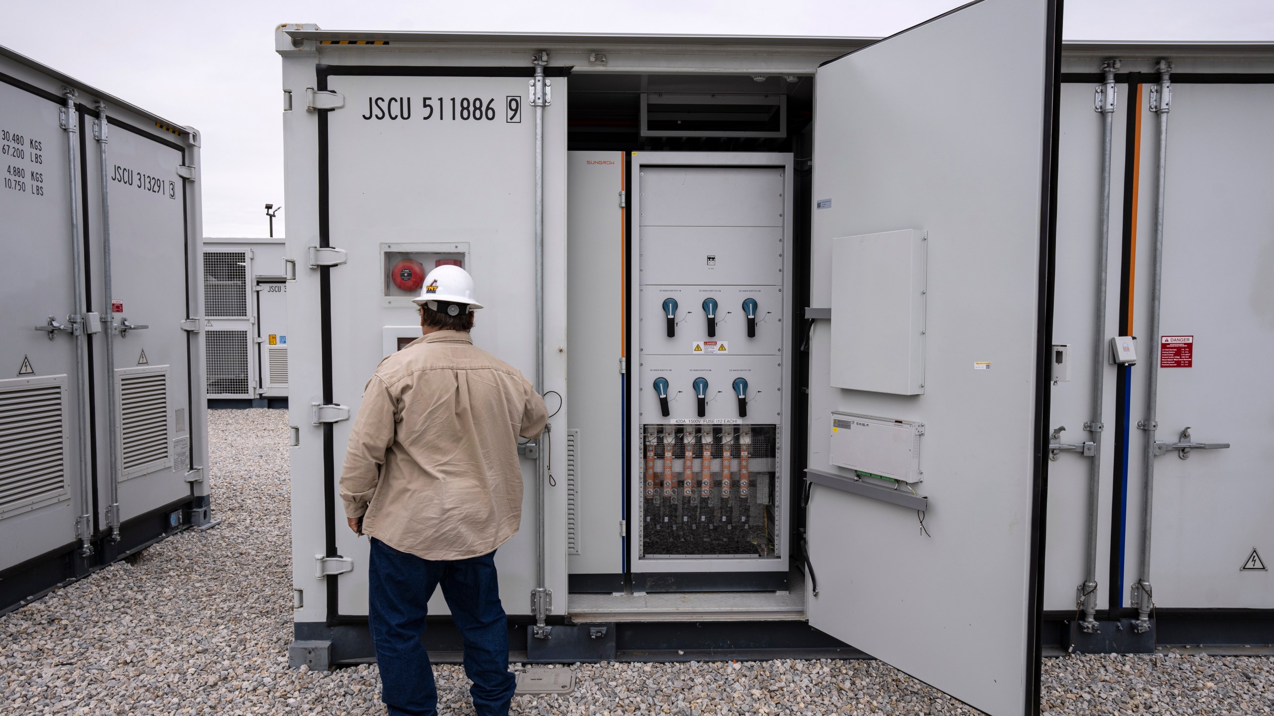 An employee works at a battery energy storage facility in Saginaw, Texas, April 25, 2023, that is owned and operated by Eolian L.P. Eolian will begin construction later this year in Portland, Ore., on projects to serve Portland General Electric, the utility that serves metropolitan Portland, the largest battery procurement of their kind outside California. (AP Photo/Sam Hodde)