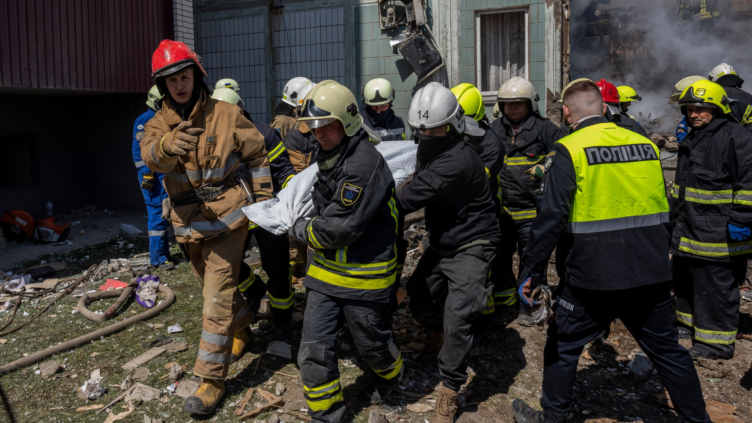 Firefighters carry a body recovered from the rubble of a residential building that was hit during a Russian attack in Uman, central Ukraine, Friday, April 28, 2023. (AP Photo/Bernat Armangue)