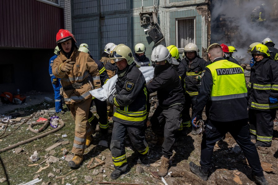 Firefighters carry a body recovered from the rubble of a residential building that was hit during a Russian attack in Uman, central Ukraine, Friday, April 28, 2023. (AP Photo/Bernat Armangue)